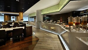 Un restaurant moderne doté d’un bar, de planchers en bois et d’un buffet proposant une variété de plats.