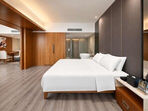 Una habitación de hotel moderna con una cama grande, un escritorio y un baño.