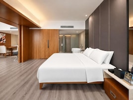 Una habitación de hotel moderna con una cama grande, un escritorio y un baño.