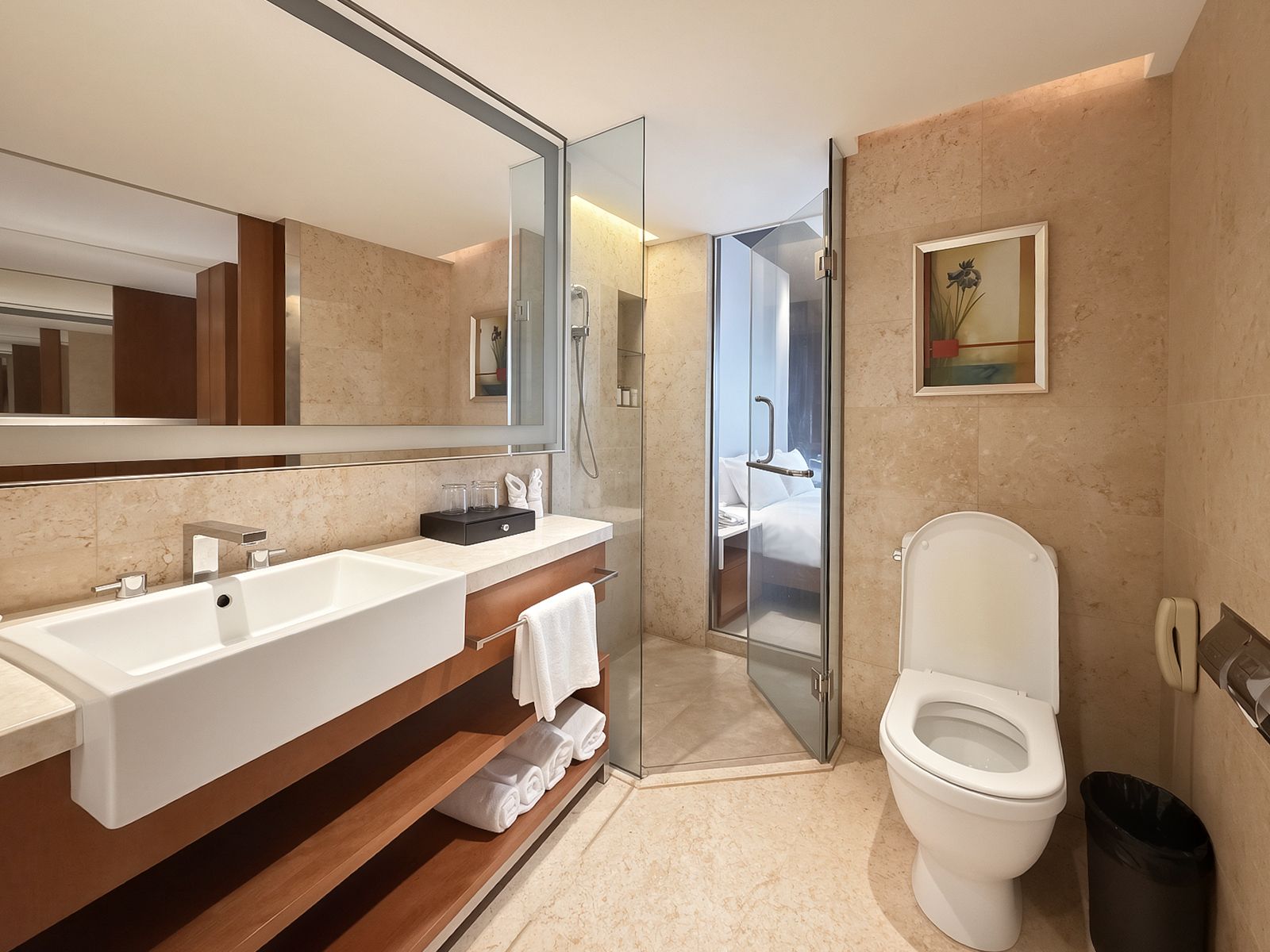 Une salle de bain moderne avec un grand miroir, un lavabo, des toilettes et un espace douche.
