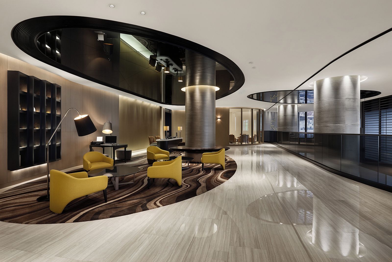 A modern lobby with a curved ceiling, a central column, and seating areas.