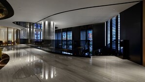 En rummelig lobby med buet loft, store vinduer og en sleben gulv.