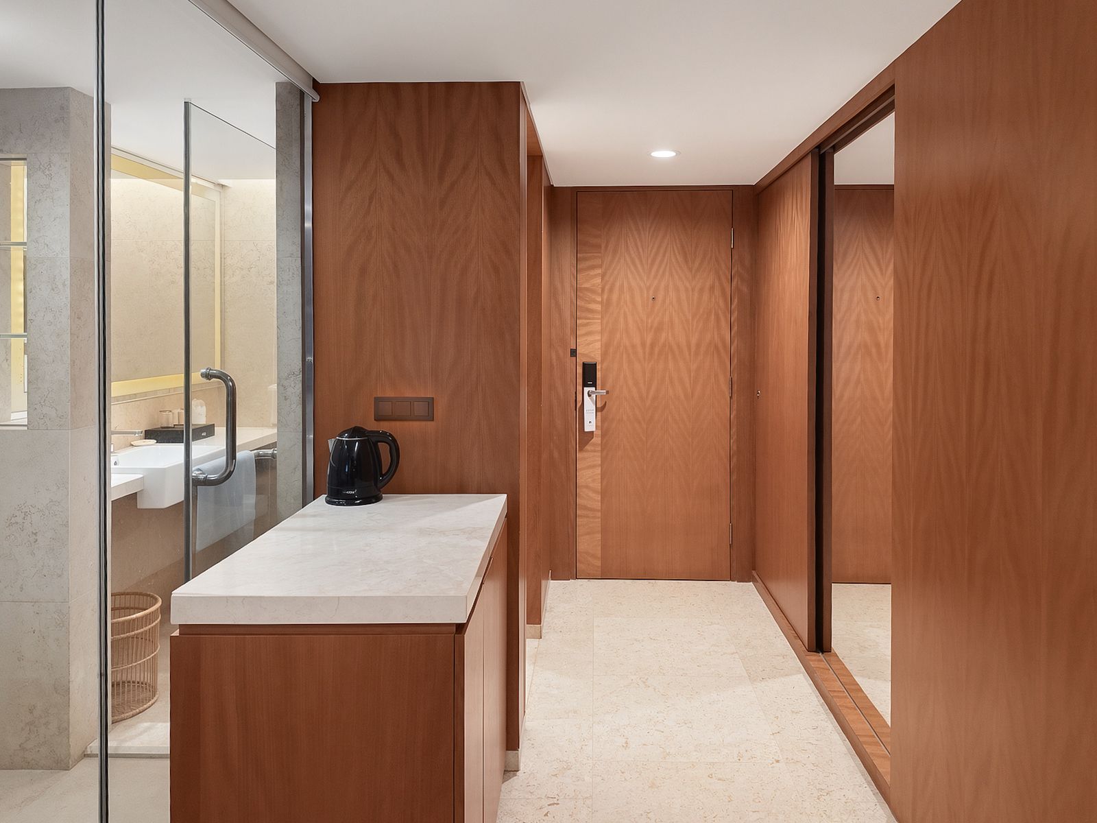 Une salle de bain moderne avec une douche à parois de verre, un comptoir blanc et une machine à café noire.