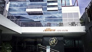A modern hotel with a glass facade, multiple balconies, and a prominent 'Allure Hotel & Suites' sign. - Allure Hotel & Suites (Mandaue)