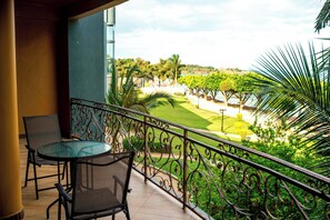 A balcony with a round glass table and two chairs, overlooking a well-maintained lawn and trees. - Protea Hotel by Marriott Entebbe (Entebbe)