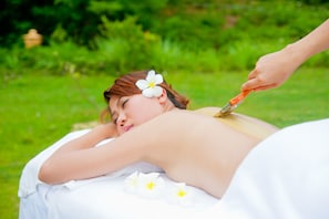 A person lying on a white surface outdoors with greenery in the background. - VietStar Resort & Spa (Binh Kien)