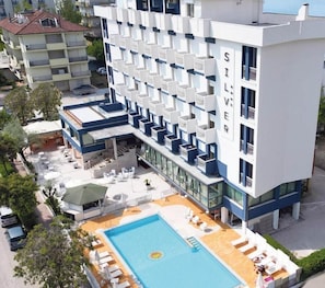 A hotel with a pool, outdoor seating, and balconies. - Hotel Silver (Cesenatico)