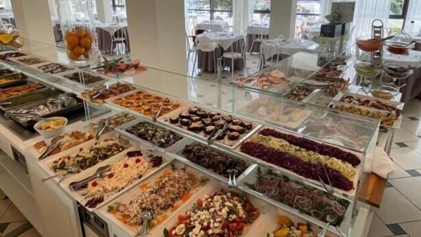 A buffet with various food options displayed in glass containers. - Hotel Silver (Cesenatico)