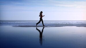 A person running on a beach with a calm sea and a clear sky in the background. - Hotel Silver (Cesenatico)