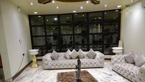 Ein geräumiges Wohnzimmer mit großem Fenster, einem мраморном журнальном столике und zwei Sofas mit Kissen.