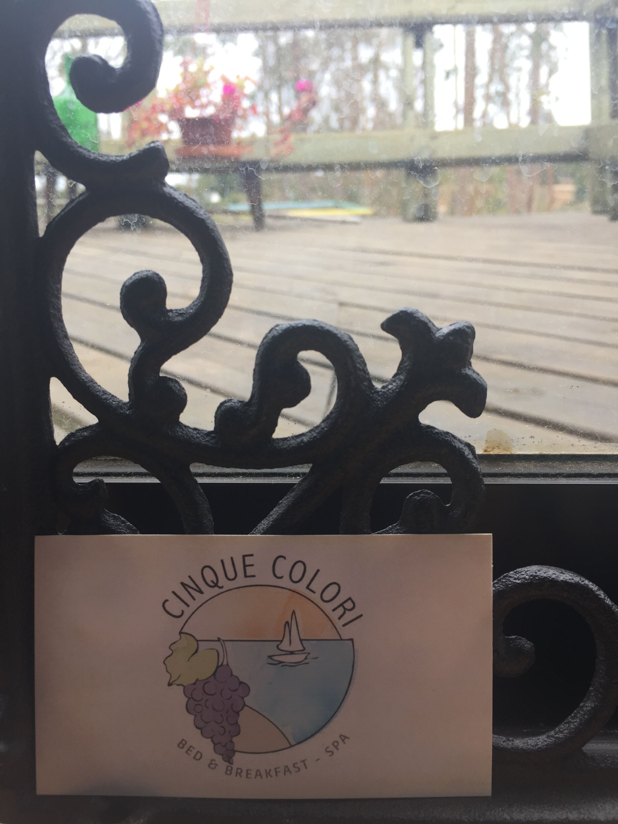 A sign with the text "CINQUE COLORI BED & BREAKFAST - SPA" on a bench.