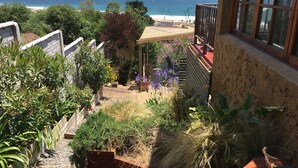 A balcony with a view of the ocean, surrounded by various plants and a small seating area. - Cinque Colori (Algarrobo)