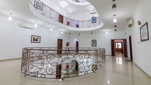 Um hall amplo com um balcão curvo, piso lustroso e design moderno no teto.