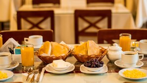 A breakfast setting with bread, cheese, fruits, coffee, and juice on a table. - Hostal Villa Sillar (Arequipa)