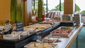A buffet with various food options, including fruits, vegetables, and a selection of cheeses and meats.