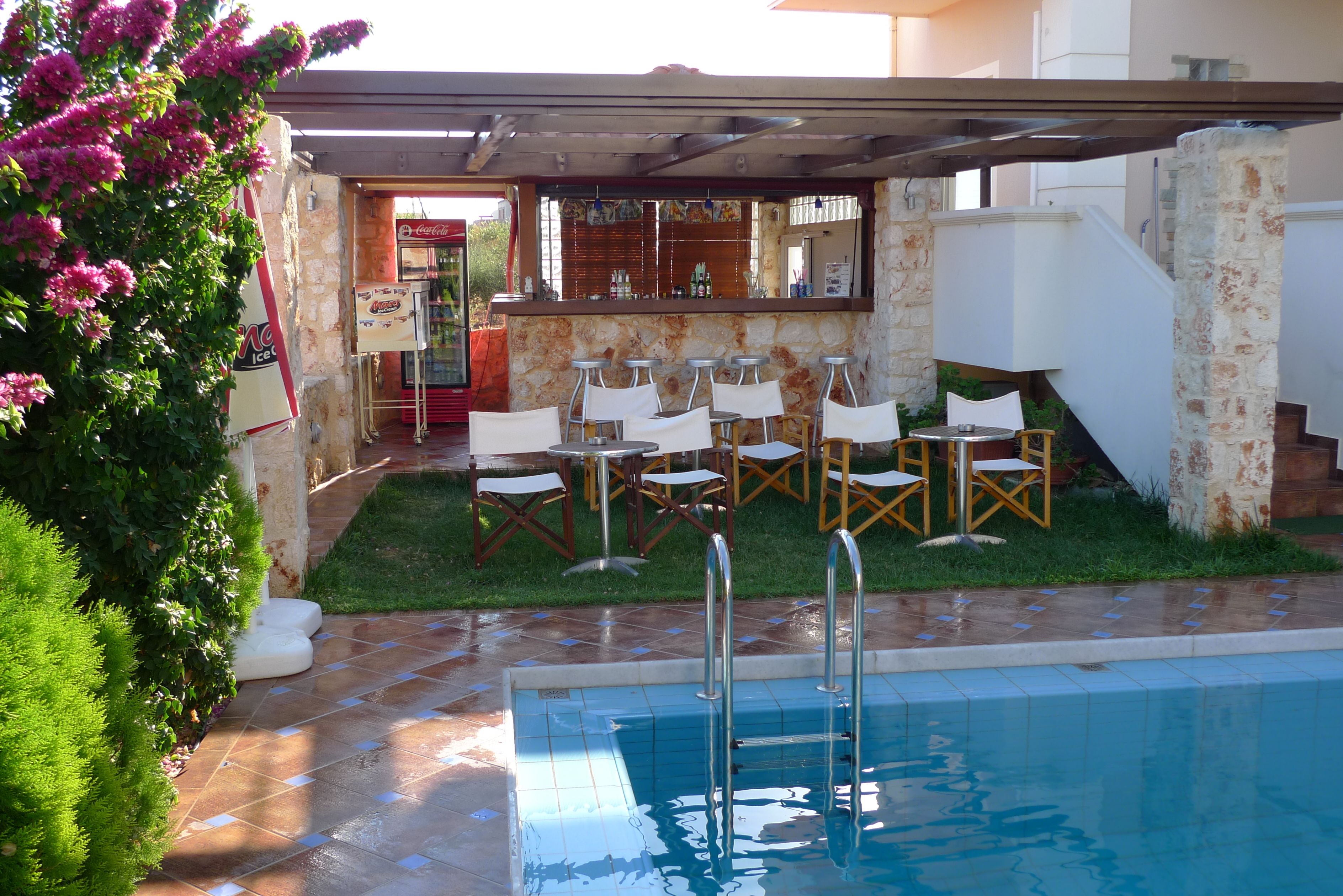 Un espace piscine extérieur doté d’un bar, de sièges et d’un mur en pierre.