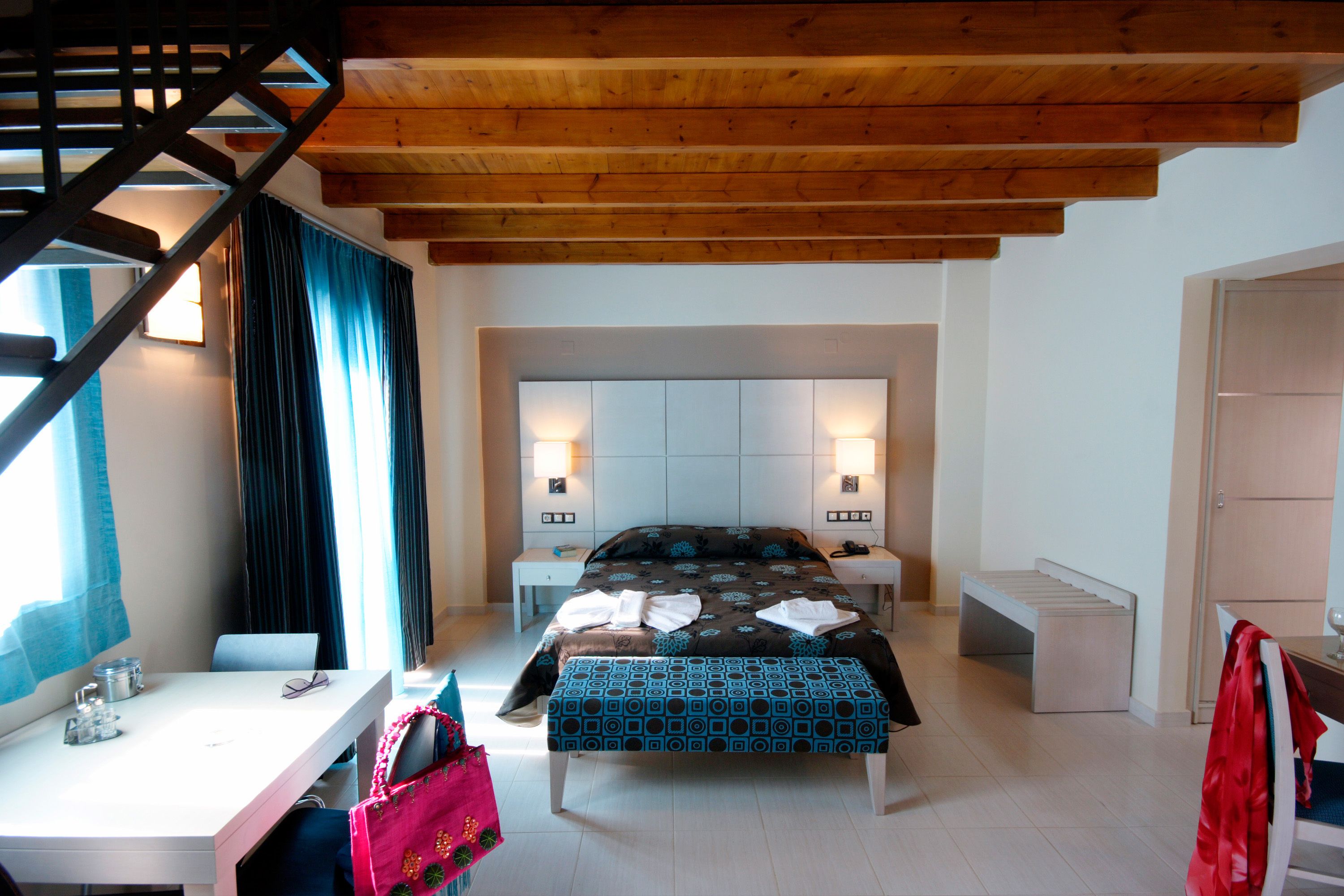 Ein Schlafzimmer mit einem Bett, Nachttischen, einem Schreibtisch und einem Stuhl.
