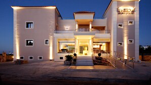 Un bâtiment moderne à deux étages, doté d’une entrée centrale, de balcons et d’une façade bien éclairée.