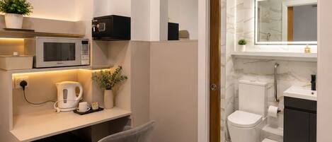 Un baño moderno con inodoro, lavamanos y espejo.