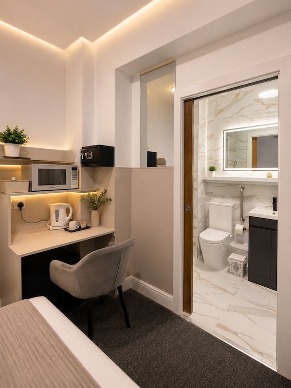Un baño moderno con inodoro, lavamanos y espejo.