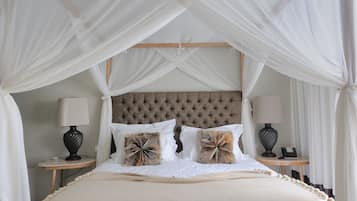 A bed with a canopy, two bedside tables with lamps, and a tufted headboard.