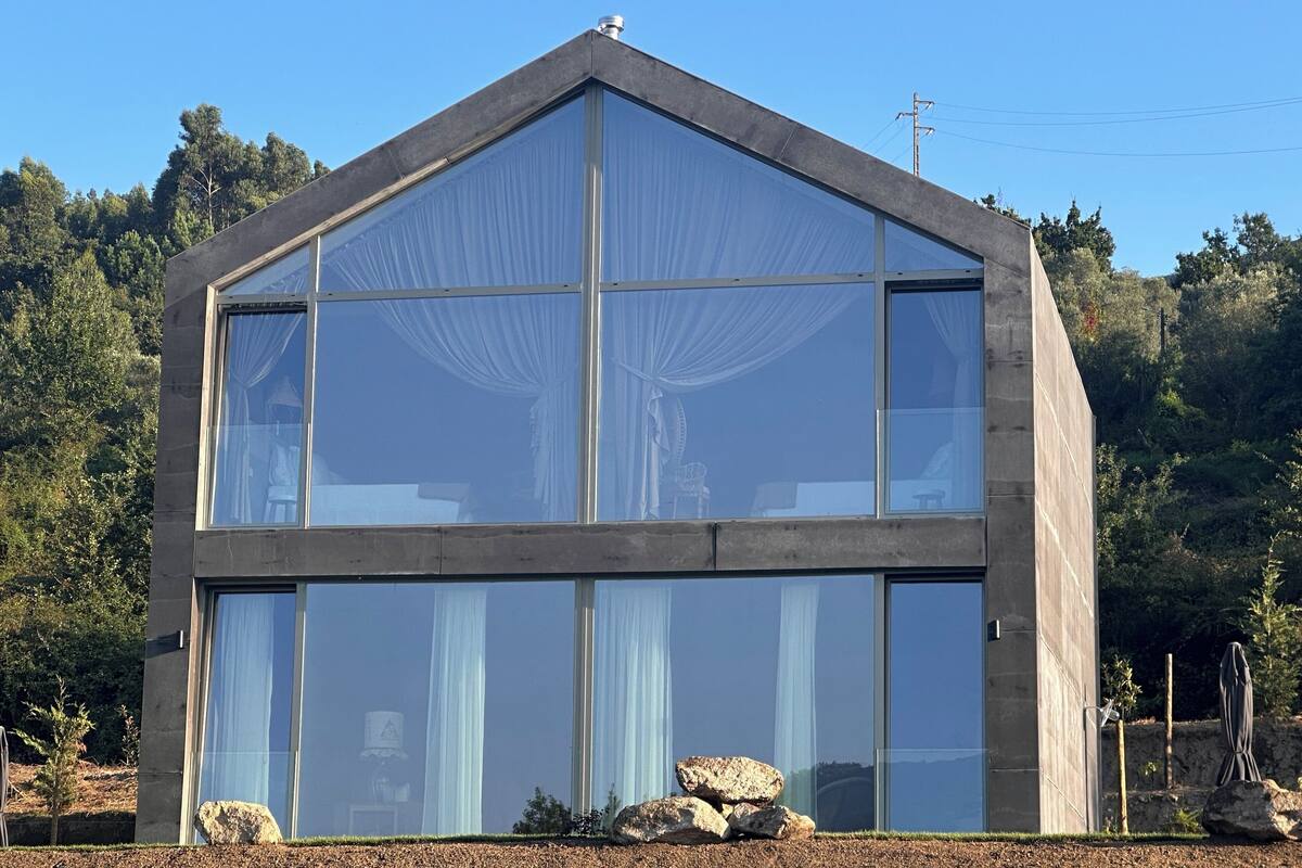 Un edificio moderno con amplios ventanales y fachada de piedra.
