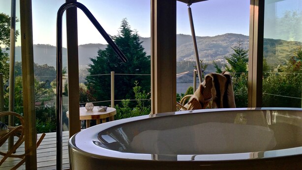 Un bain à remous sur une terrasse offrant une vue sur un paysage montagneux.
