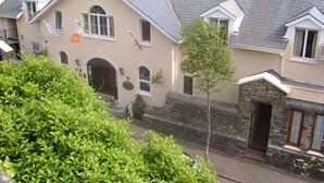 A hotel with a sign reading "Waters Edge Hotel" and a view of the water in the background. - WatersEdge Hotel (Cobh)