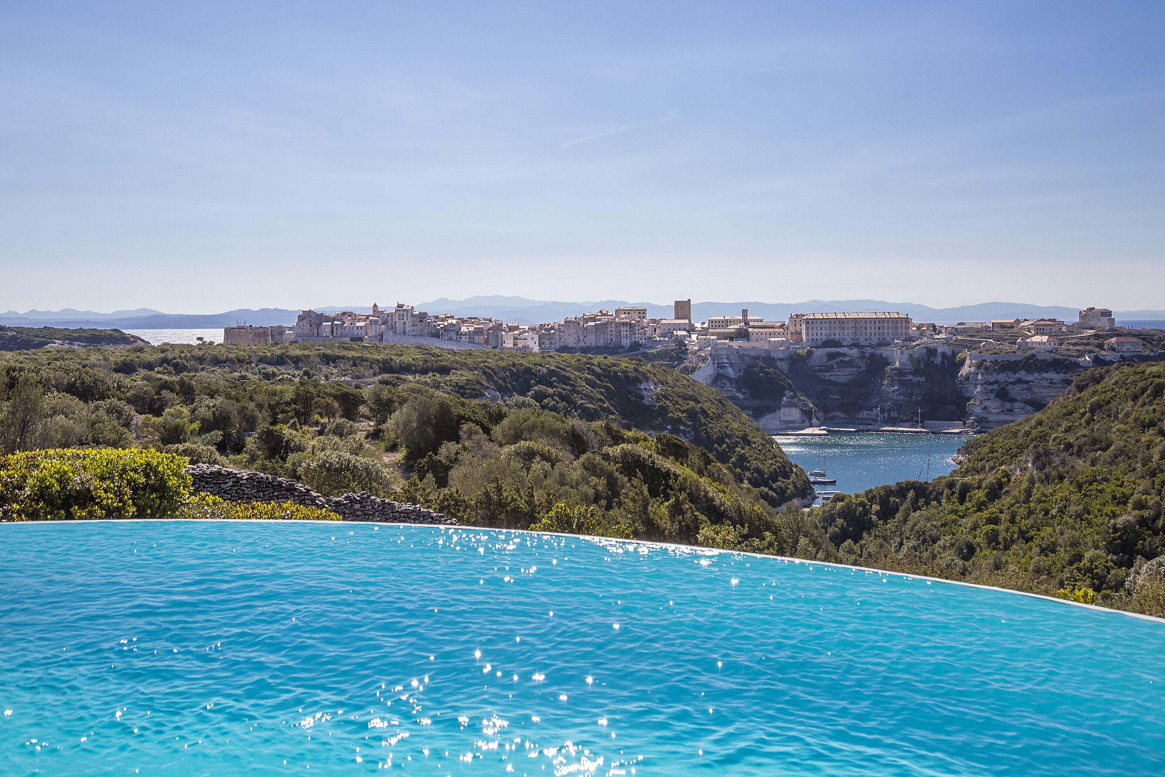 Un pueblo costero con vistas claras al mar y una piscina grande.