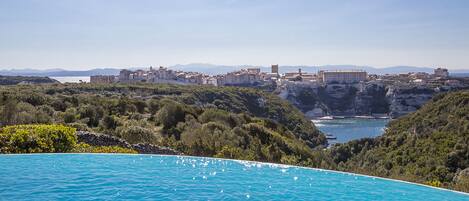 Un pueblo costero con vistas claras al mar y una piscina grande.