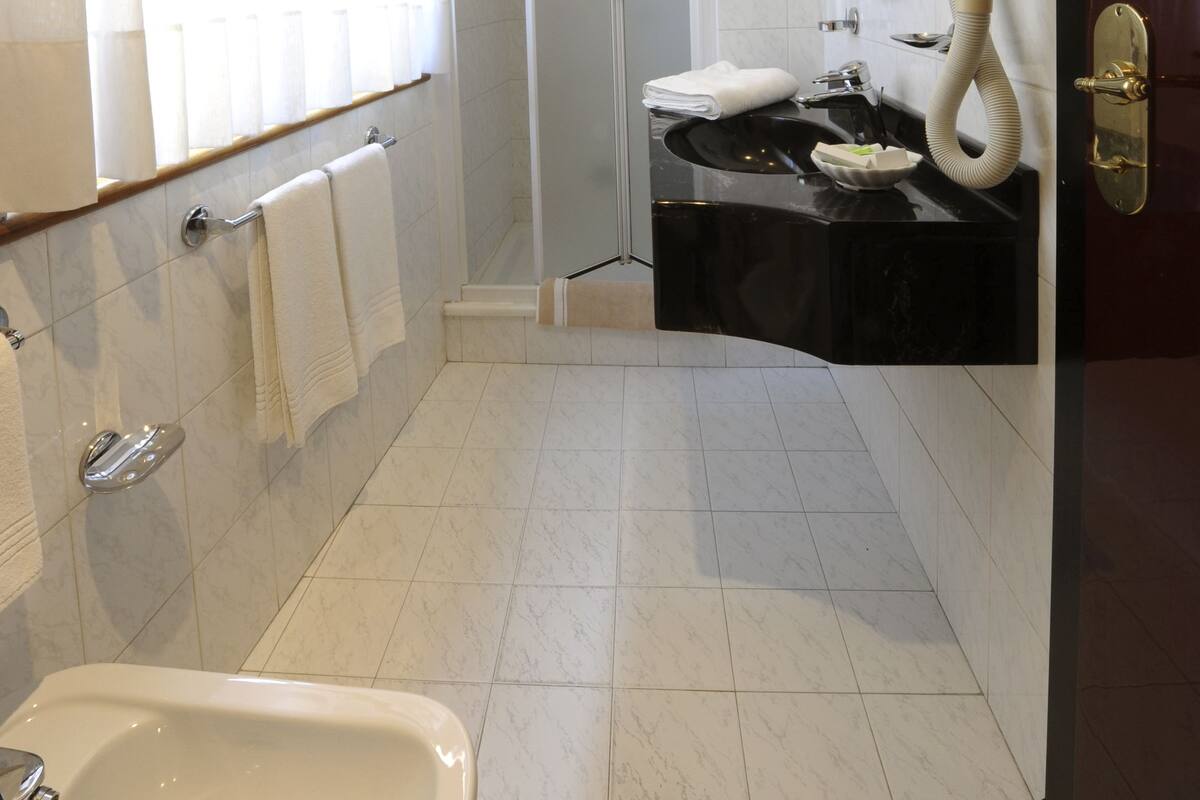 Un baño moderno con una bañera, un lavabo con espejo, ducha e inodoro.