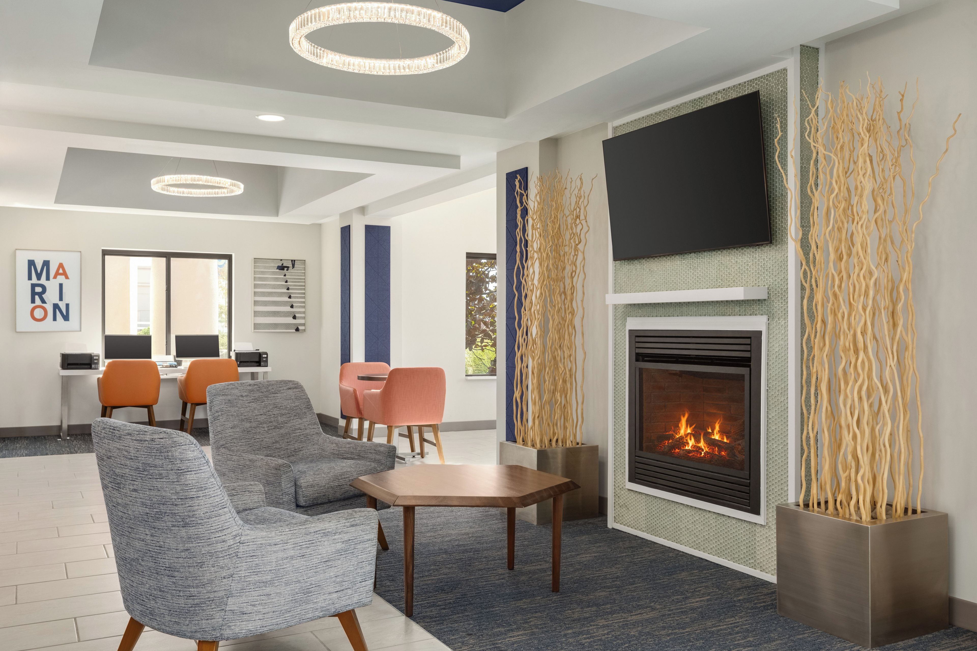 Una sala de estar moderna con chimenea, asientos y televisor.