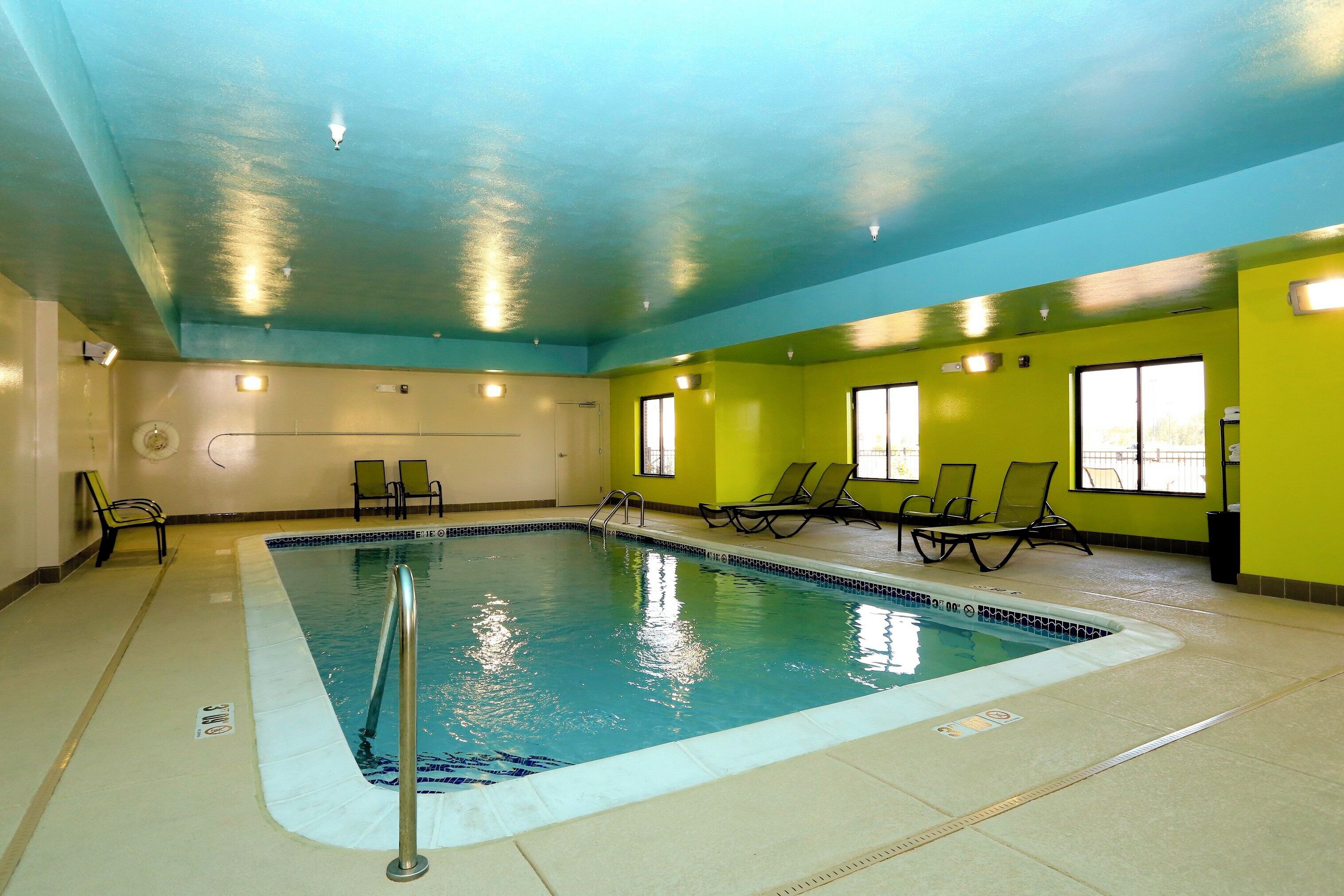 Una piscina techada, sillones reclinables de piscina