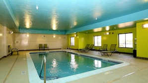 An indoor swimming pool with a tiled edge, a metal ladder, and several lounge chairs. - Holiday Inn Express Hotel & Suites Marion Northeast by IHG (Marion)