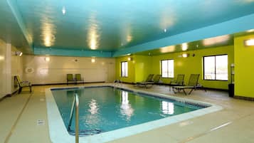 Una piscina techada, sillones reclinables de piscina