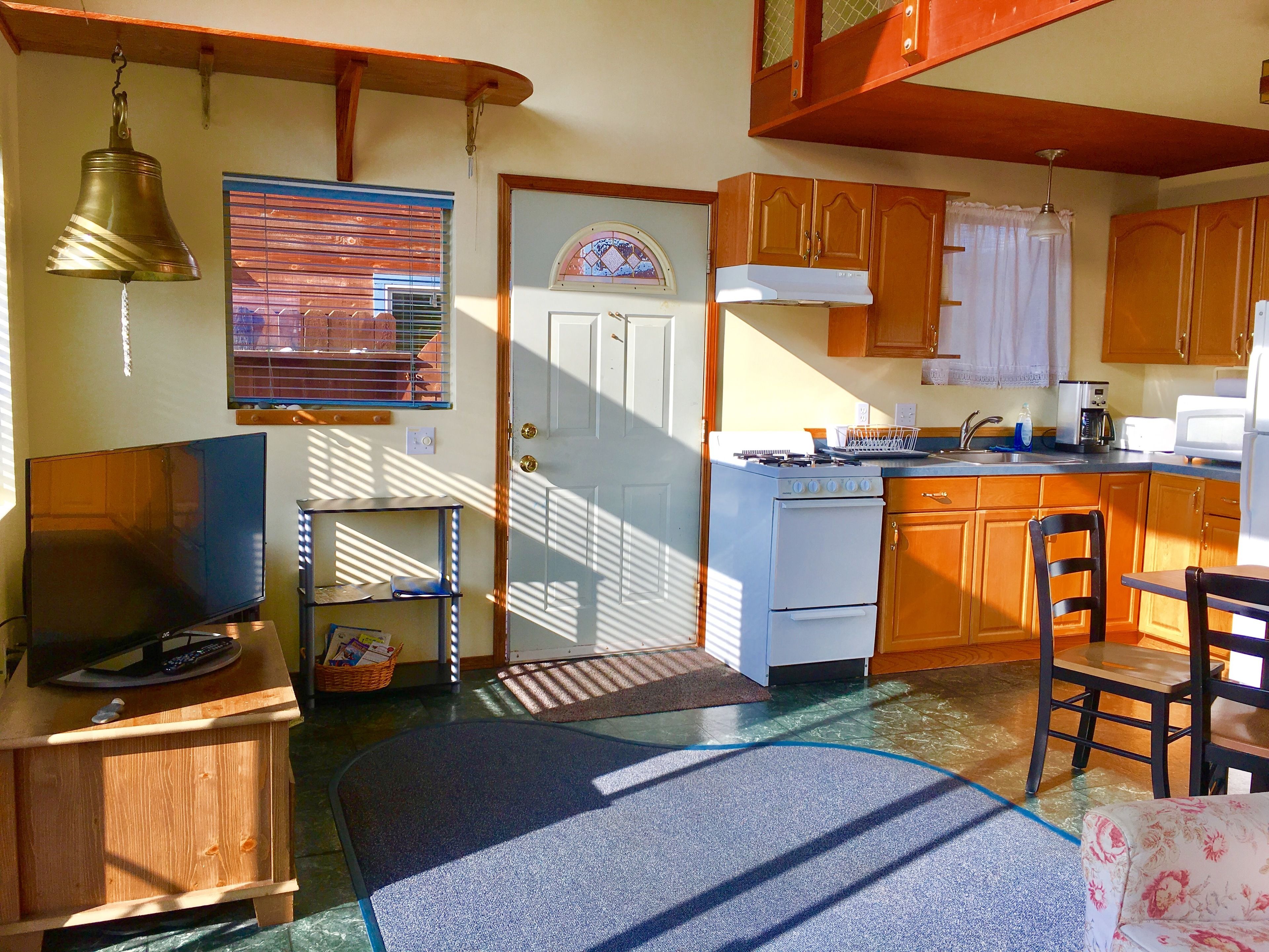 A kitchen with wooden cabinets, a stove, a sink, and a microwave.