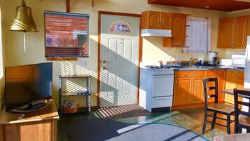 A kitchen with wooden cabinets, a stove, a sink, and a microwave.