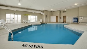 An indoor swimming pool with a 'NO DIVING' sign, a sunshade, and a view of the outside. - Baymont by Wyndham Evansville North/Haubstadt (Haubstadt)