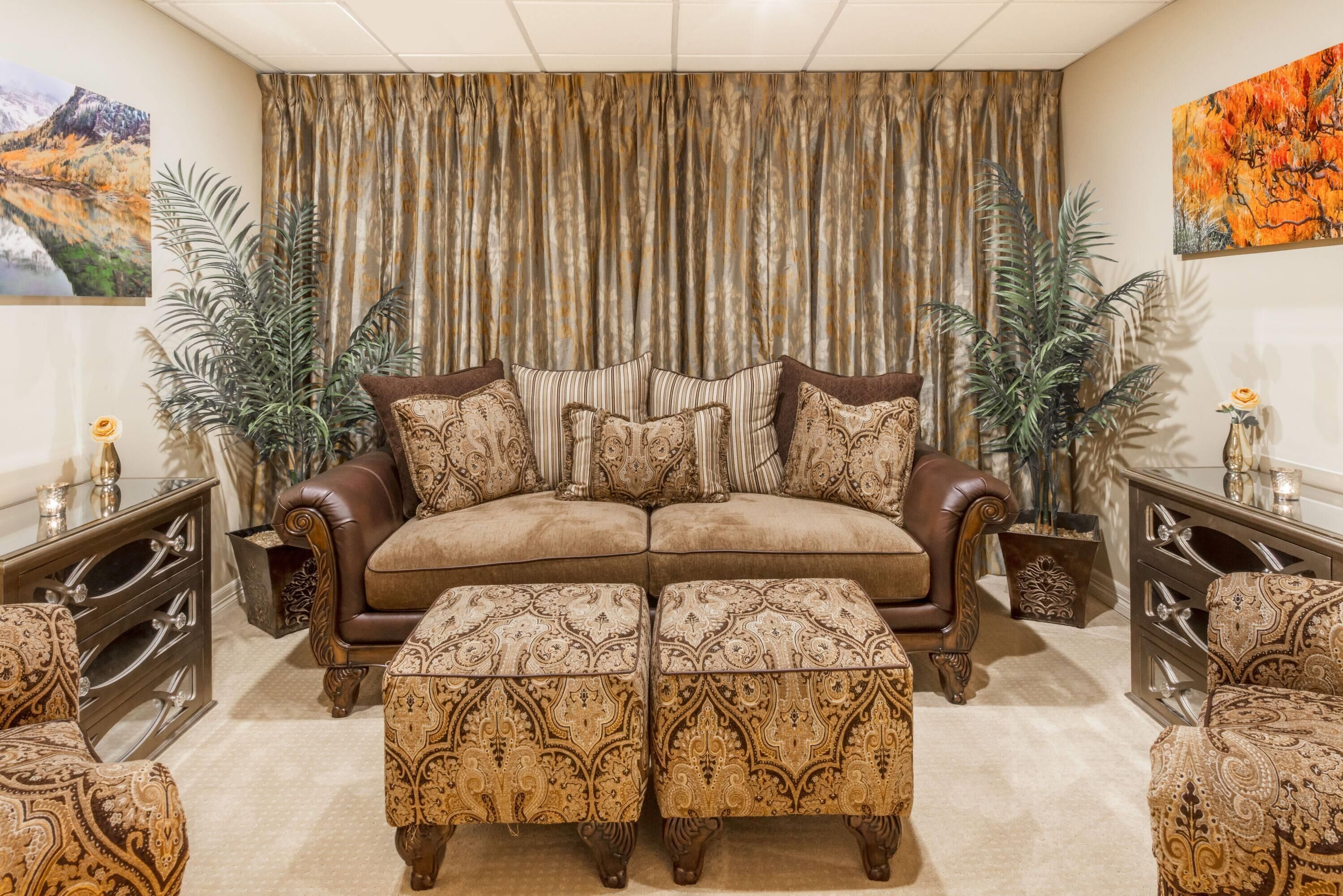 A living room with a sofa, ottomans, and two side tables with decorative items.