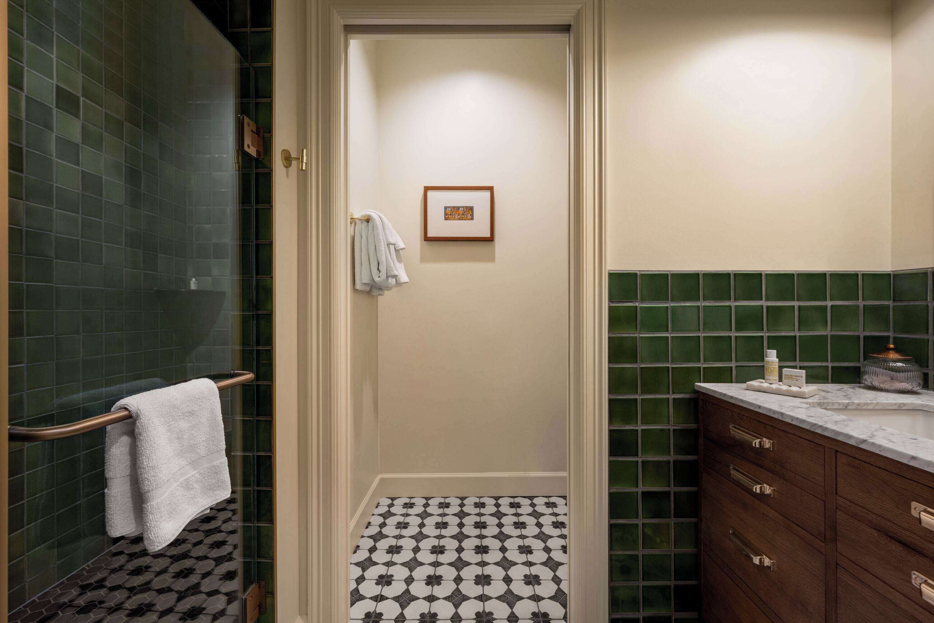 Ein Badezimmer mit Duschbereich, Toilette und Waschbecken mit Marmorplatte.