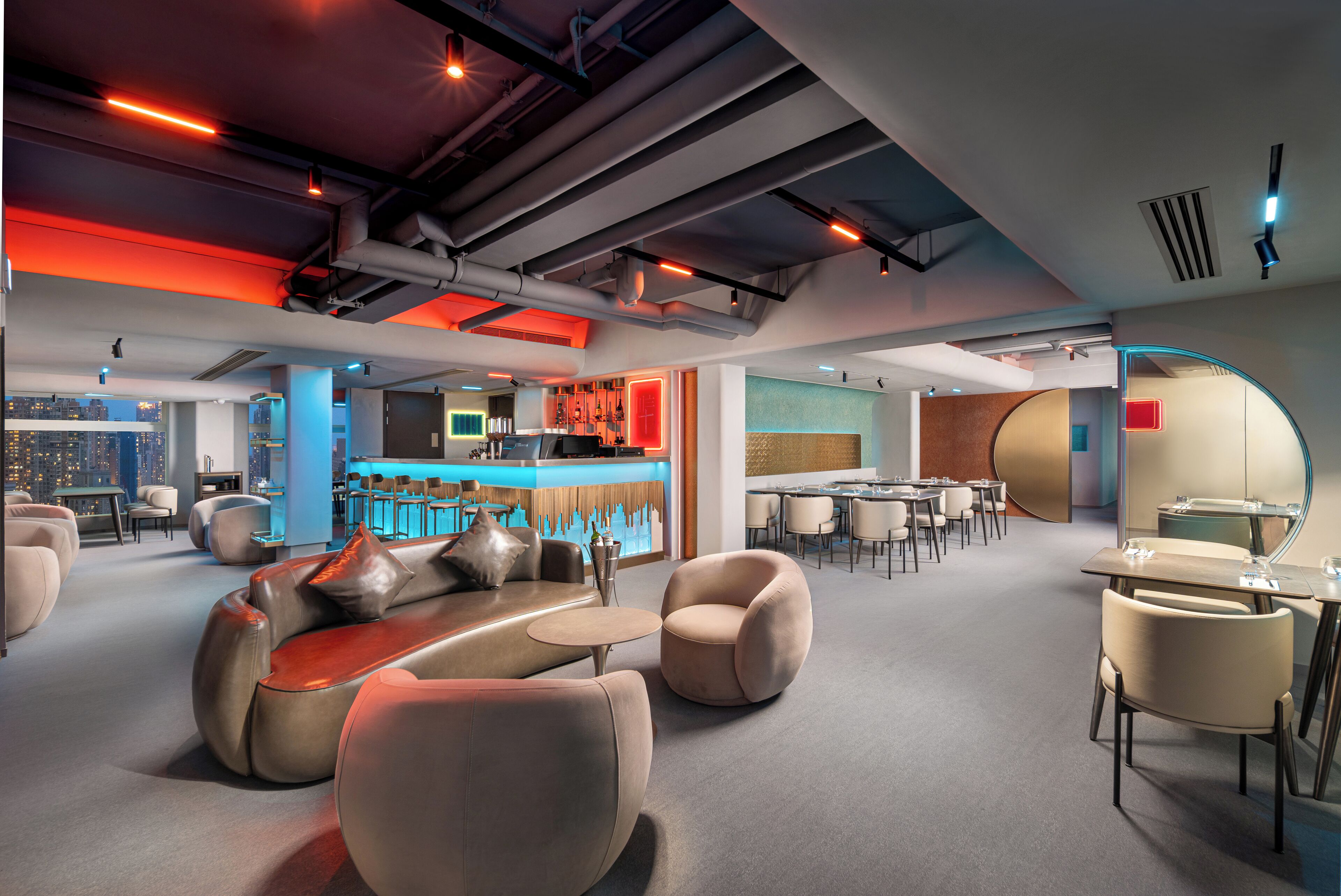 Et moderne loungeområde med sofaer, lænestole og en bar.