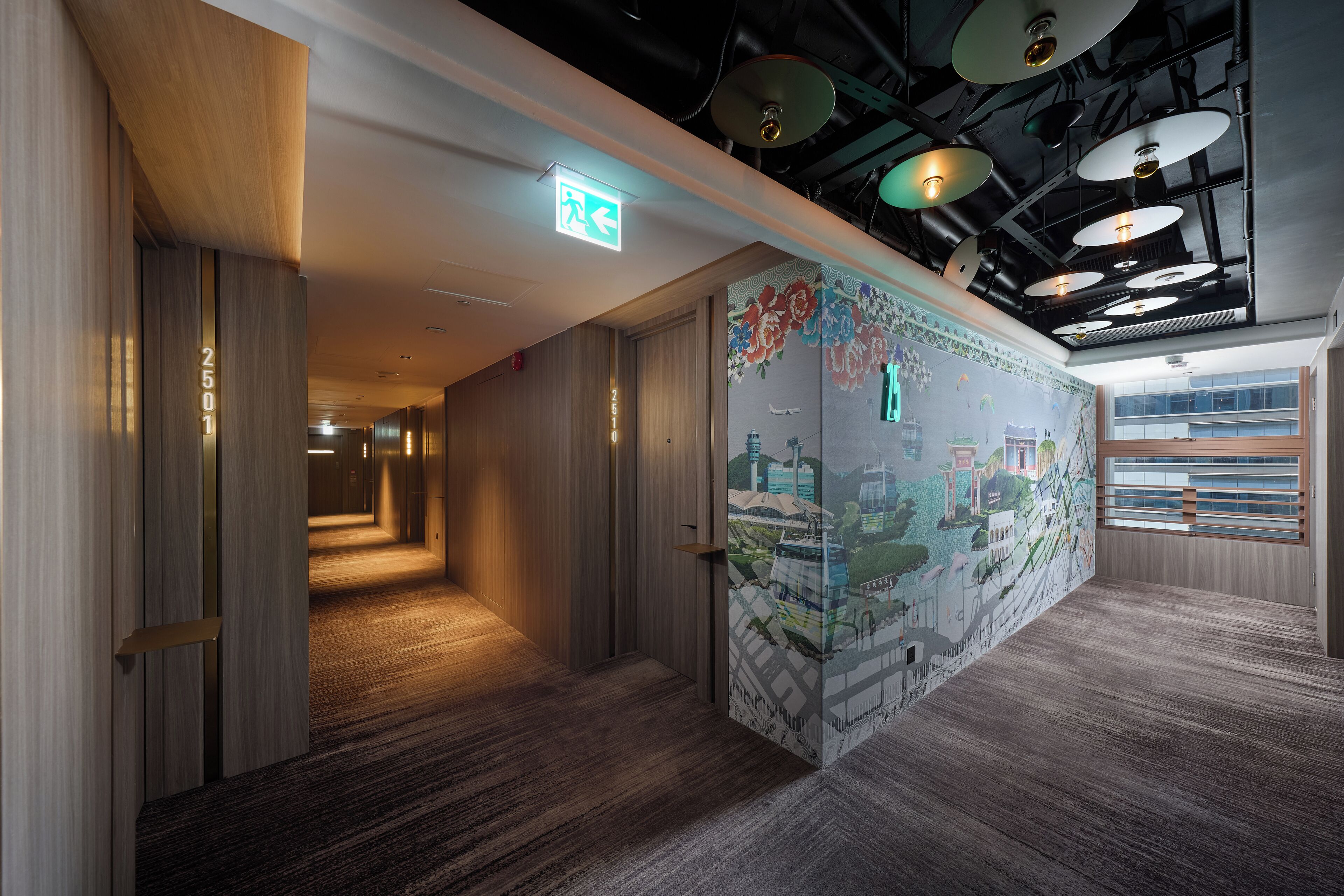 A modern hotel corridor with wooden walls, a carpeted floor, and a mural depicting a cityscape.