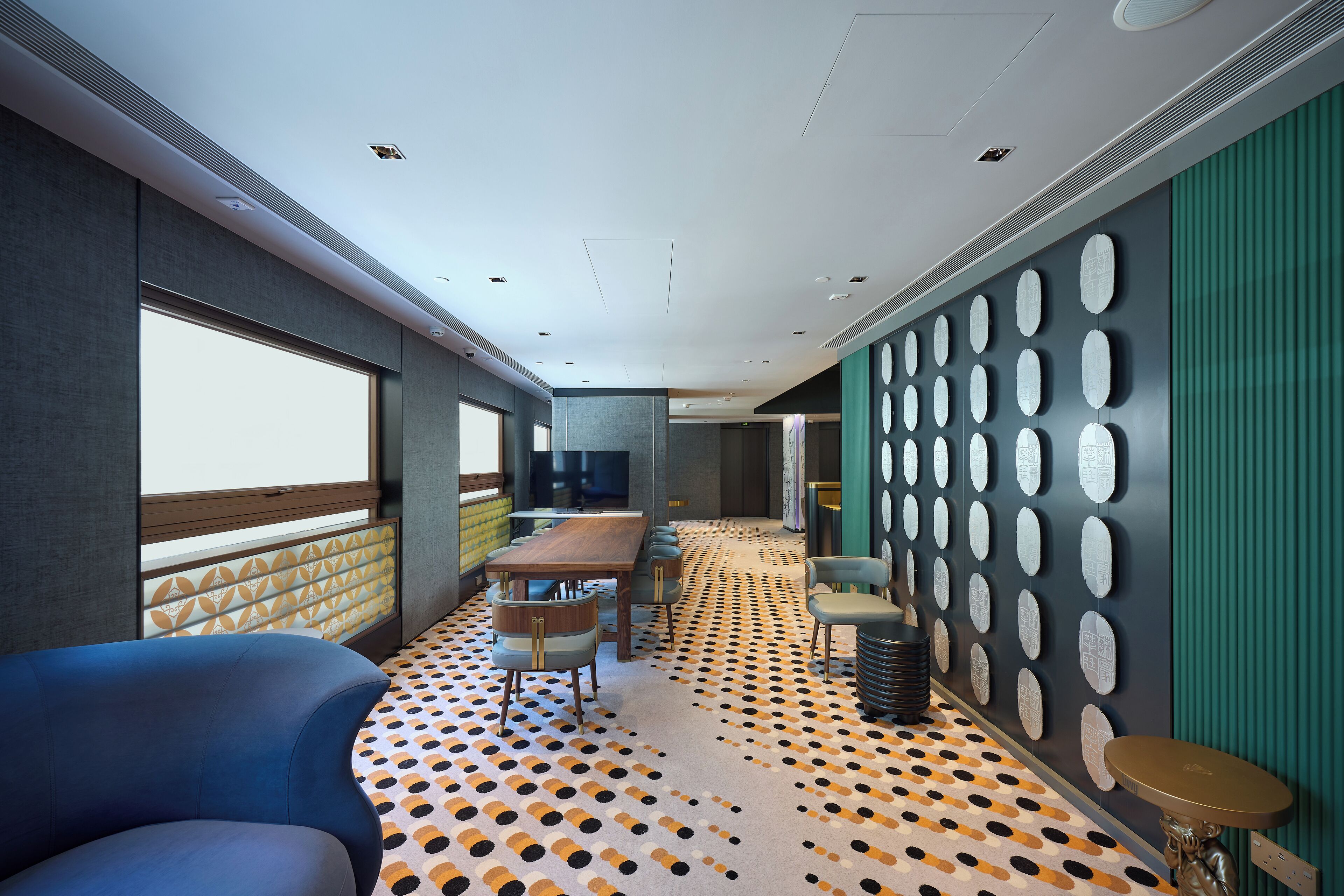 A modern interior with a patterned carpet, a dining area, and a wall with circular decorations.