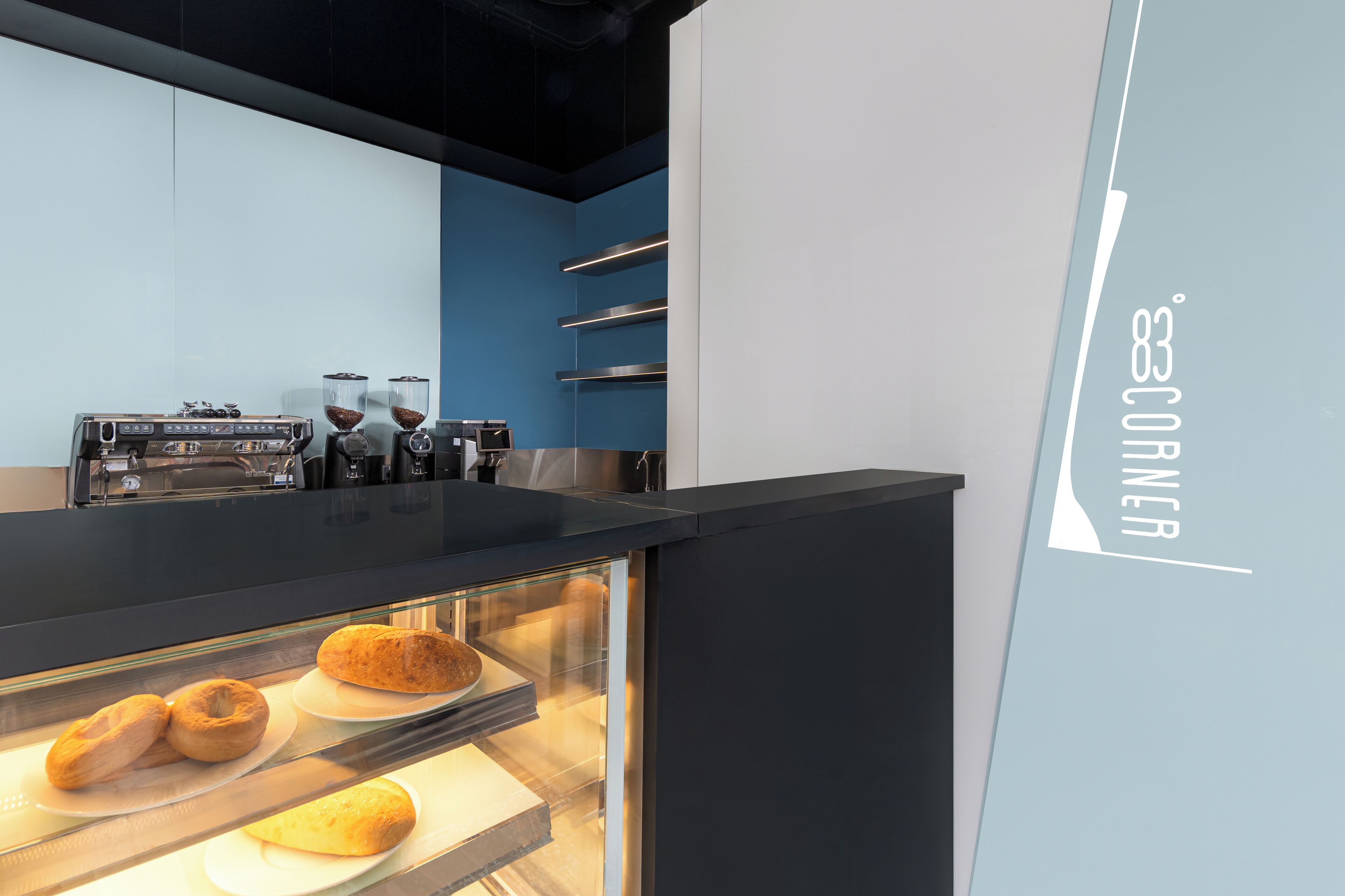 Een bakkerijdisplay met gebak en een koffiemachine.