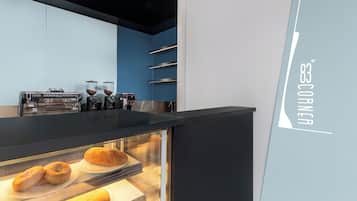 Een bakkerijdisplay met gebak en een koffiemachine.