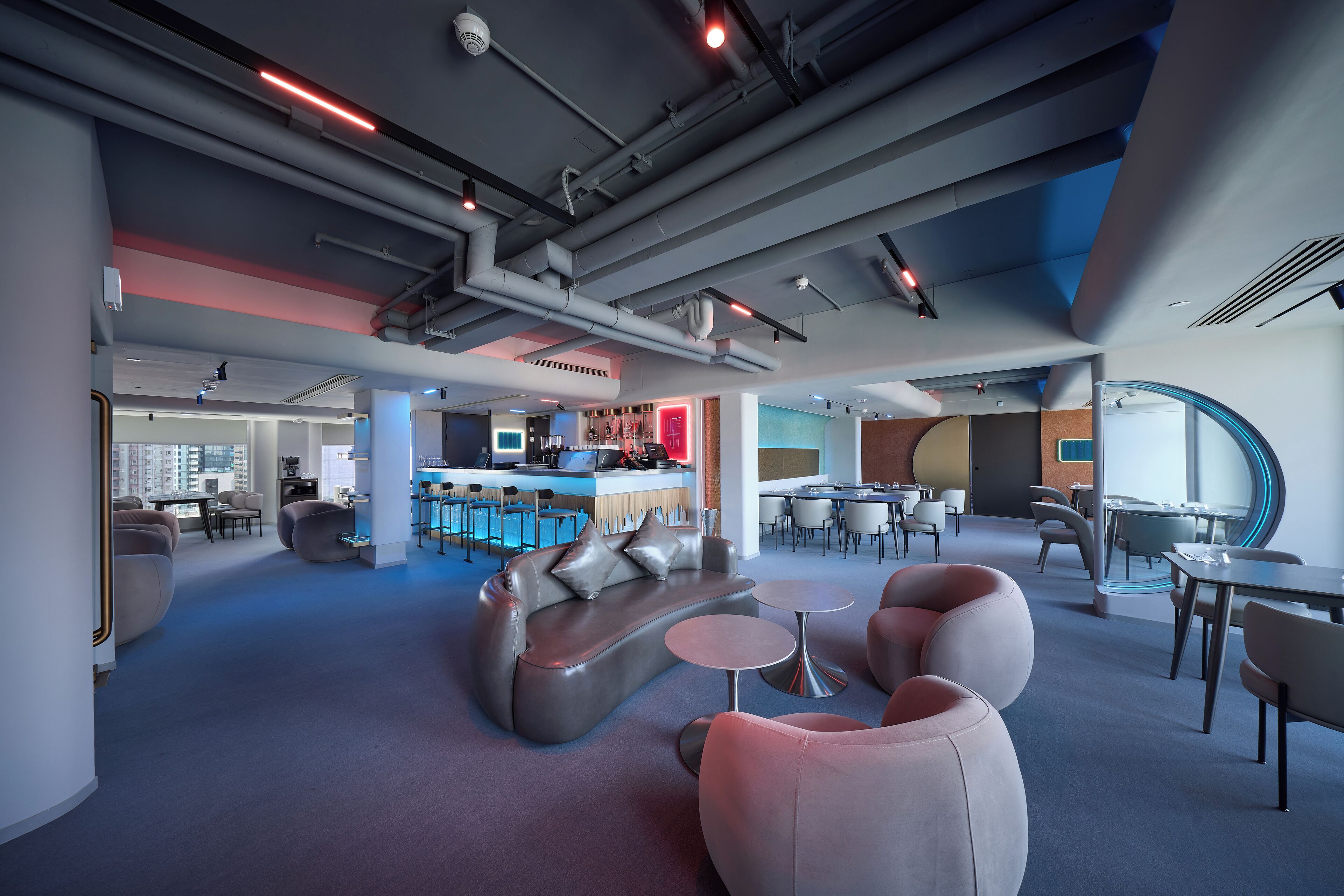 Un espace lounge moderne avec des sièges, des tables et un bar.