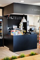 Zona de recepción de un hotel con un mostrador negro, una computadora y un letrero que dice "HOTELES".