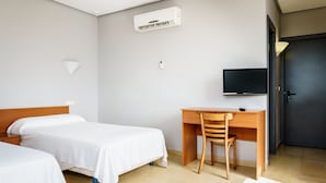 A hotel room with two single beds, a wooden desk, a chair, a television, and a door. - As Hotels Chucena (Chucena)