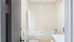 A modern bathroom with a bathtub, a sink, and a toilet. - As Hotels Chucena (Chucena)