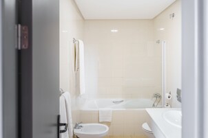 Un baño moderno con bañera, lavabo e inodoro.